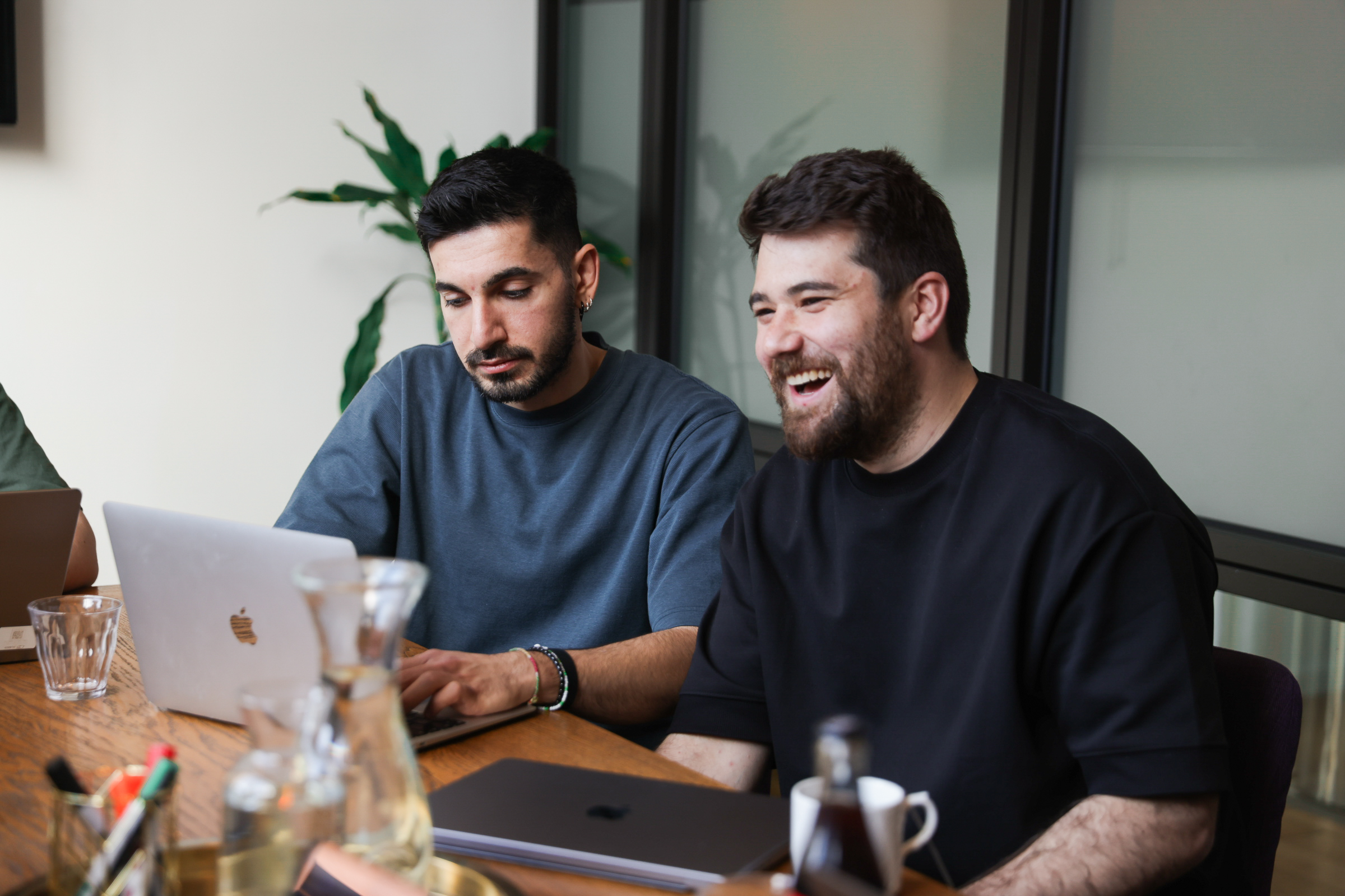 Zwei Fidarion-Teammitglieder am Laptop, informelle Arbeitssituation im Büro
